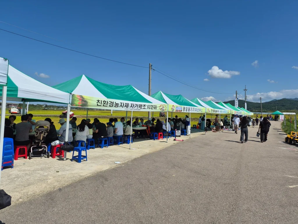 Local residents gathering under tents at a harvest festival in rural Korea