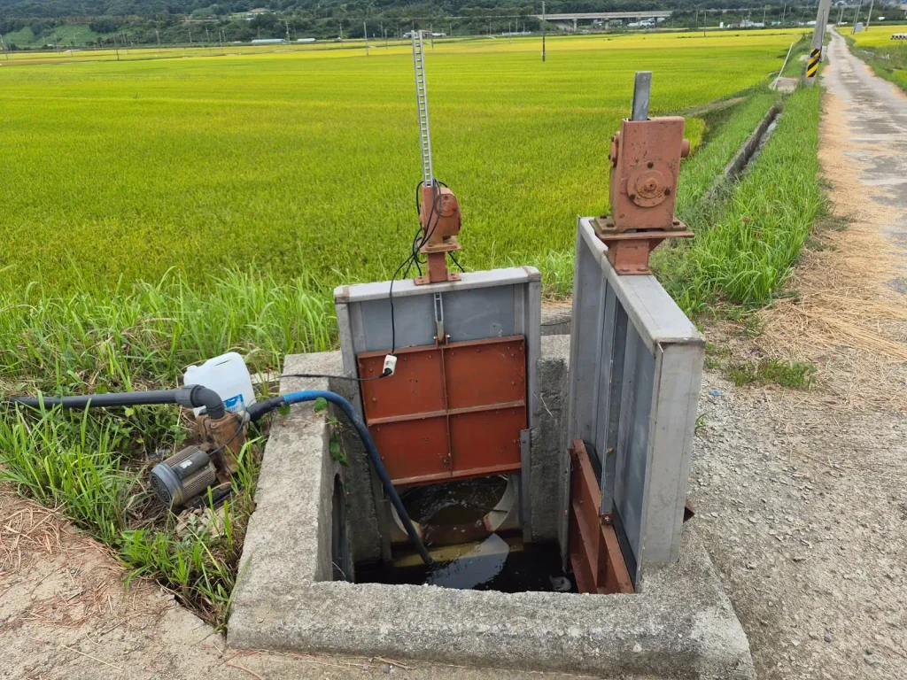 Water-control gate and small pump beside rice fields in rural South Korea