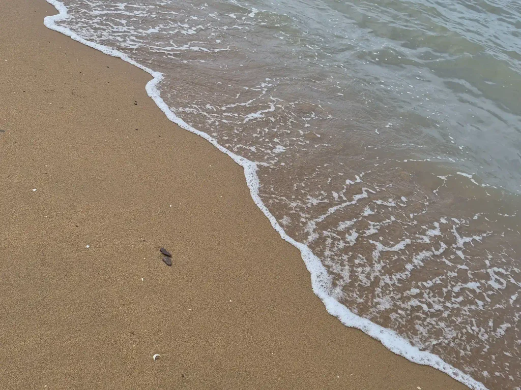 Small waves reaching a sandy beach on the coast of rural Yeonggwang, South Korea