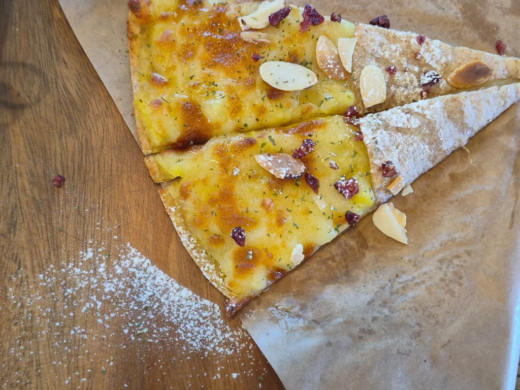 Partially eaten brunch dish with golden baked topping, sliced almonds and dried fruit served at Armeria Café in Gochang